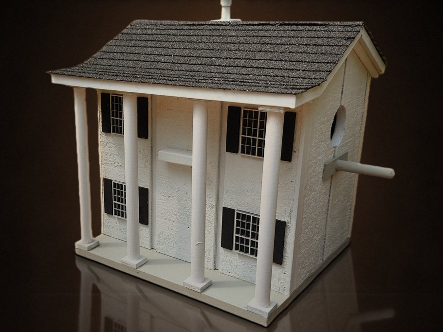 White two-story house birdhouse with columns, black shutters and a real shingle roof