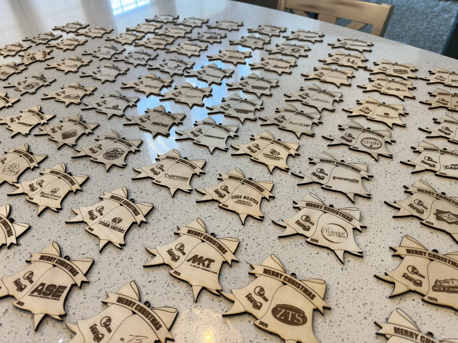 Custom engraved business logo ornaments laid out in the shop