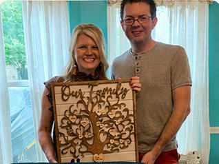 Couple holding the custom family tree made for their family