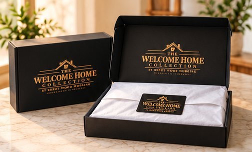 Open branded black gift box with white tissue paper and a Welcome Home Collection story card